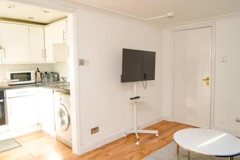Bright and modern kitchen area with white cabin...
