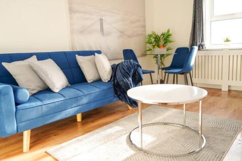 Bright and modern living room featuring a styli...