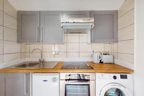 A modern kitchen featuring grey cabinets, a sma...