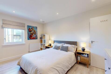 A bright and inviting bedroom featuring a comfo...