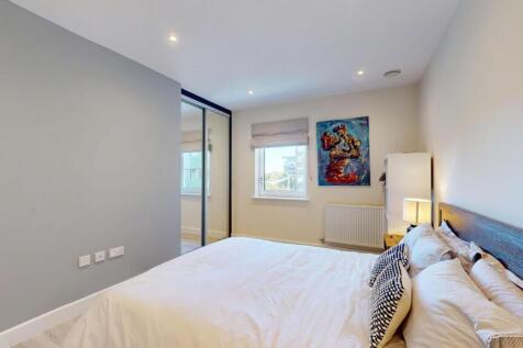 A spacious master bedroom featuring a comfortab...