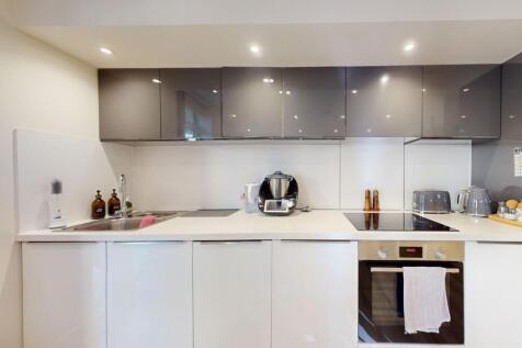 Modern kitchen with sleek white cabinets, stain...