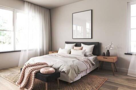A bright and airy master bedroom featuring a co...