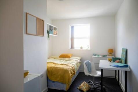 A bright and tidy single bedroom featuring a co...
