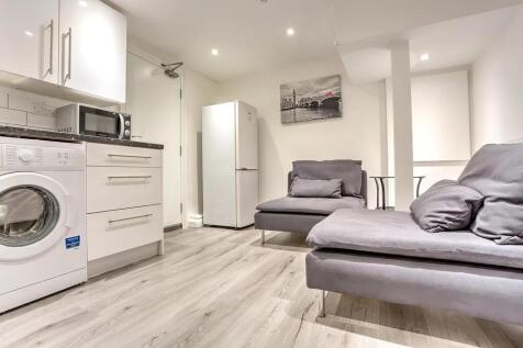 A modern kitchen area featuring sleek white cab...
