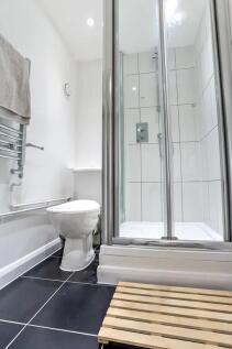 A modern bathroom featuring a sleek tiled showe...