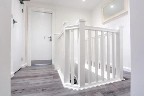 Bright and clean hallway featuring modern white...