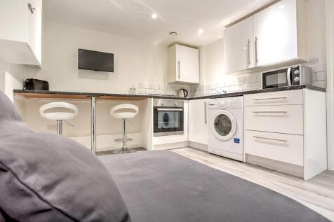 Modern and clean kitchen with white cabinetry a...