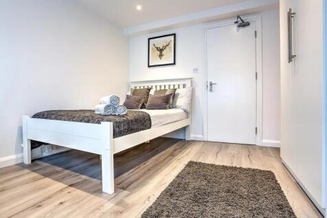 Bright and modern double bedroom featuring a st...