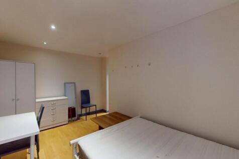 A clean, well-lit bedroom featuring a single be...