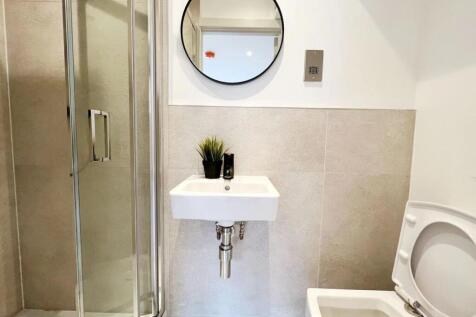 Modern bathroom featuring a compact sink, a sho...