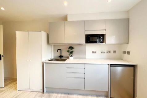 Modern and minimalist kitchen with sleek, light...