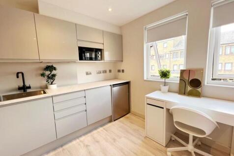 Bright and modern kitchen featuring sleek white...