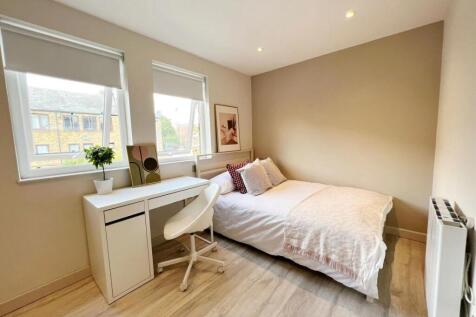 Bright and cozy single bedroom featuring a comf...