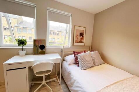 A bright and cozy bedroom featuring a comfortab...