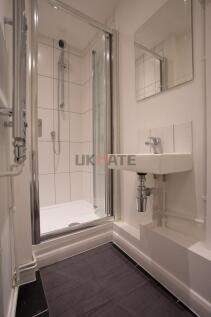 A clean and compact bathroom featuring a shower...