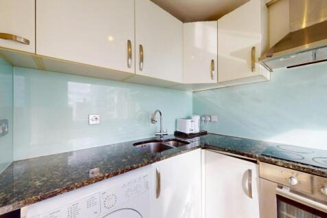 Modern kitchen with glossy white cabinets, a da...