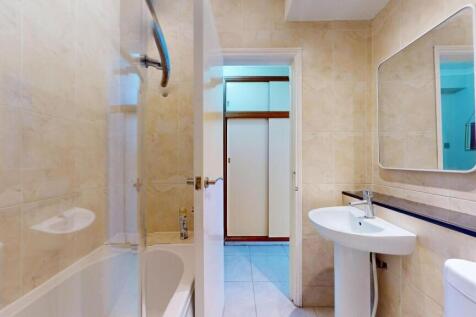 Bright and clean bathroom featuring a shower, s...
