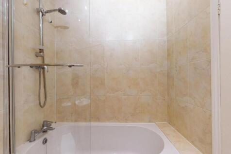 A clean and spacious bathroom with a large bath...