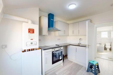 Bright, modern kitchen with white cabinetry, a ...