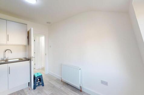 A bright, minimalist kitchen with white cabinet...