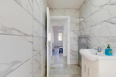 Modern bathroom featuring white marble-effect t...