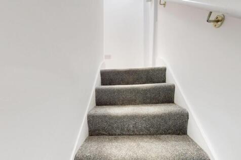 An indoor staircase with carpeted steps, simple...