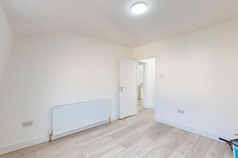 A bright, clean bedroom with white walls, a rad...