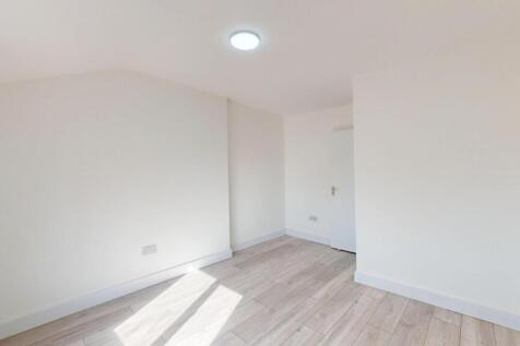 Bright, freshly painted bedroom with light wood...