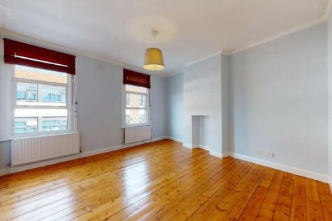 Bright double bedroom featuring polished wooden...