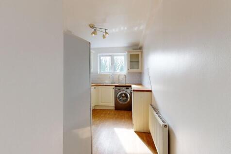 Bright and clean kitchen featuring white cabine...