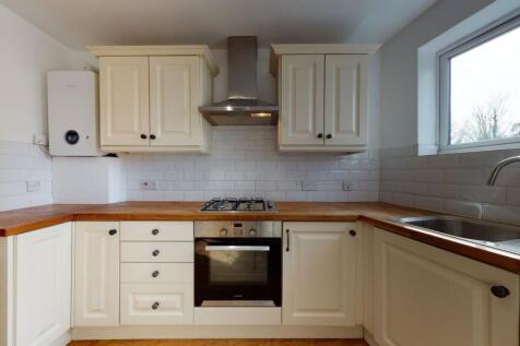 Bright and clean kitchen featuring cream cabine...