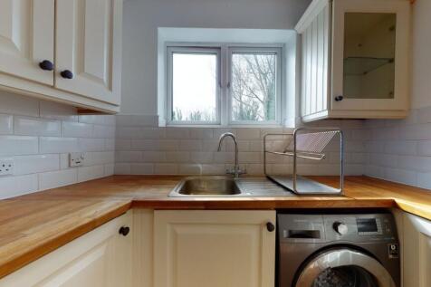 Bright and tidy kitchen featuring cream cabinet...