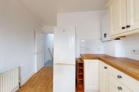 Bright and tidy kitchen featuring cream cabinet...