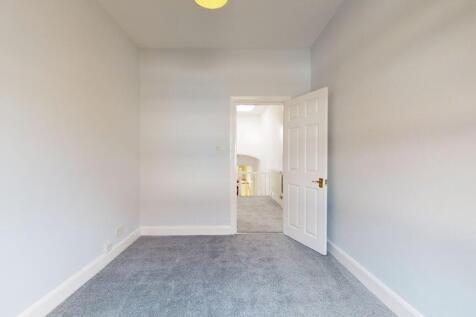 A clean and freshly carpeted single bedroom wit...