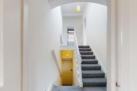 Bright and clean hallway with white walls and g...