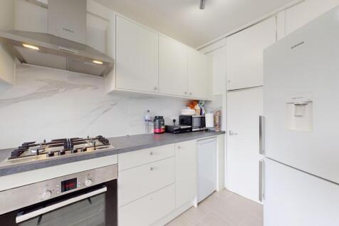 A modern, clean kitchen with white cabinets, a ...