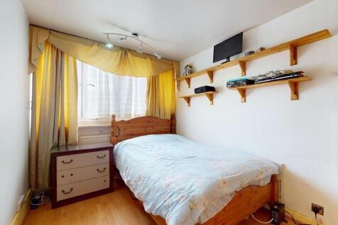 A cozy double bedroom featuring a wooden bed, a...