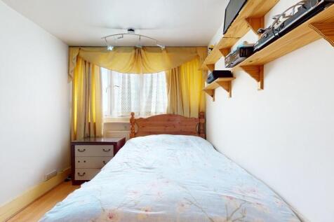 A cozy bedroom featuring a wooden bed frame wit...