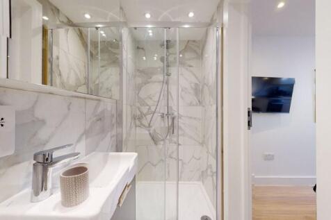 A modern bathroom featuring stylish marble-effe...