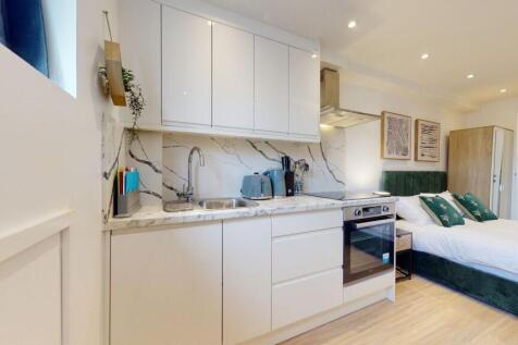 A modern and tidy studio bedroom featuring a co...