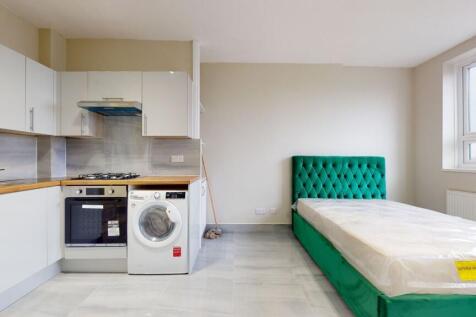 Modern kitchen area with white cabinetry, woode...