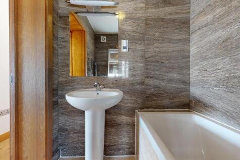 Modern bathroom featuring a white bathtub, a pe...
