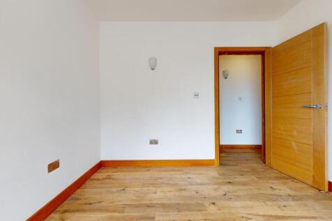 Bright, freshly painted bedroom with warm wood-...