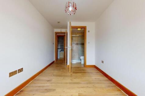 Bright, freshly painted bedroom with warm wood ...