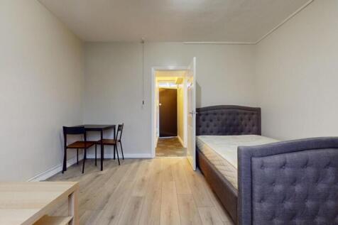 A neat and inviting single bedroom with a cushi...