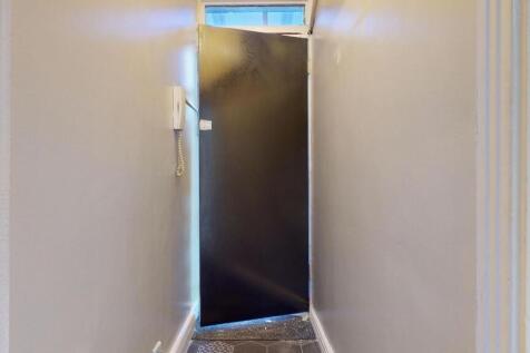 A narrow hallway with clean, neutral-colored wa...