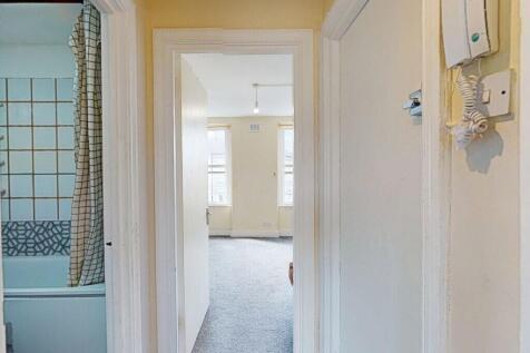 A bright hallway with neutral walls and carpete...