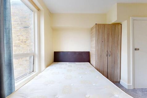 A bright double bedroom featuring a comfortable...
