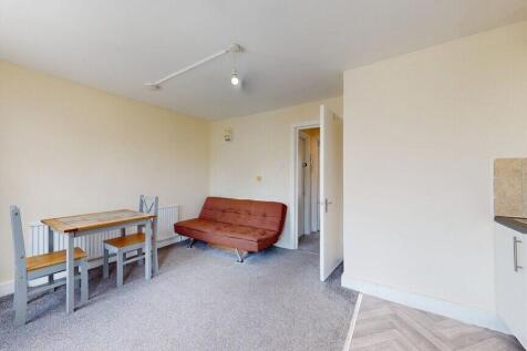 A cozy living room featuring a compact dining t...